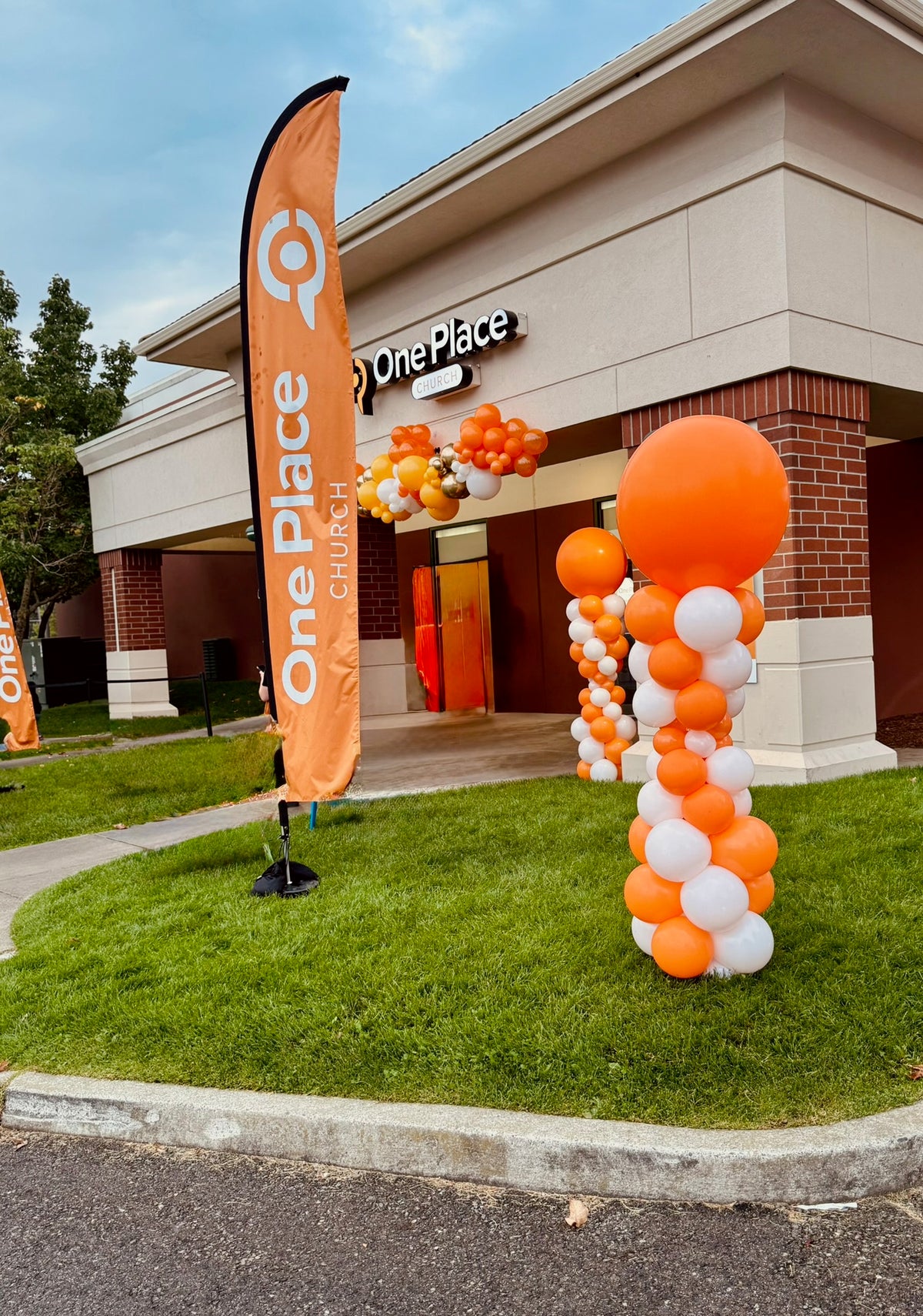 Orange and white spiral balloon columns at a storefront