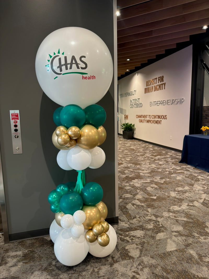 Party pole with a CHAS Health logo balloon in an office lobby
