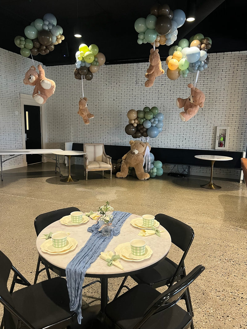 Teddy bear baby shower room with ceiling balloon clusters