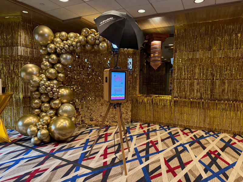 Gold shimmer wall with chrome gold balloon garland and photo booth