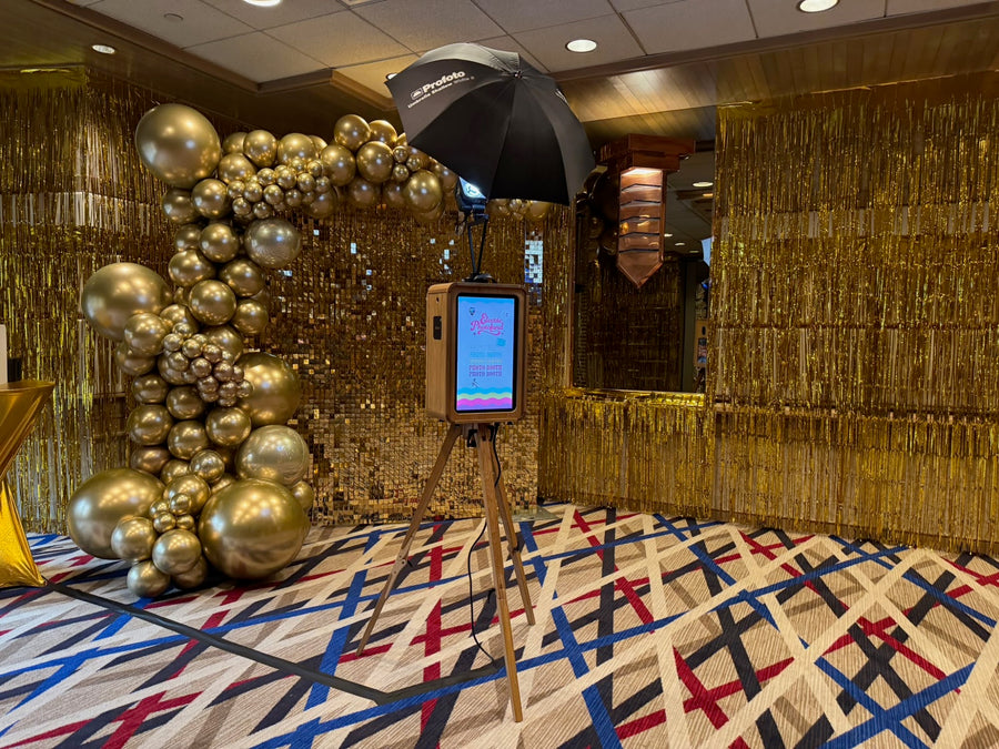 Gold shimmer wall with chrome gold balloon garland and photo booth