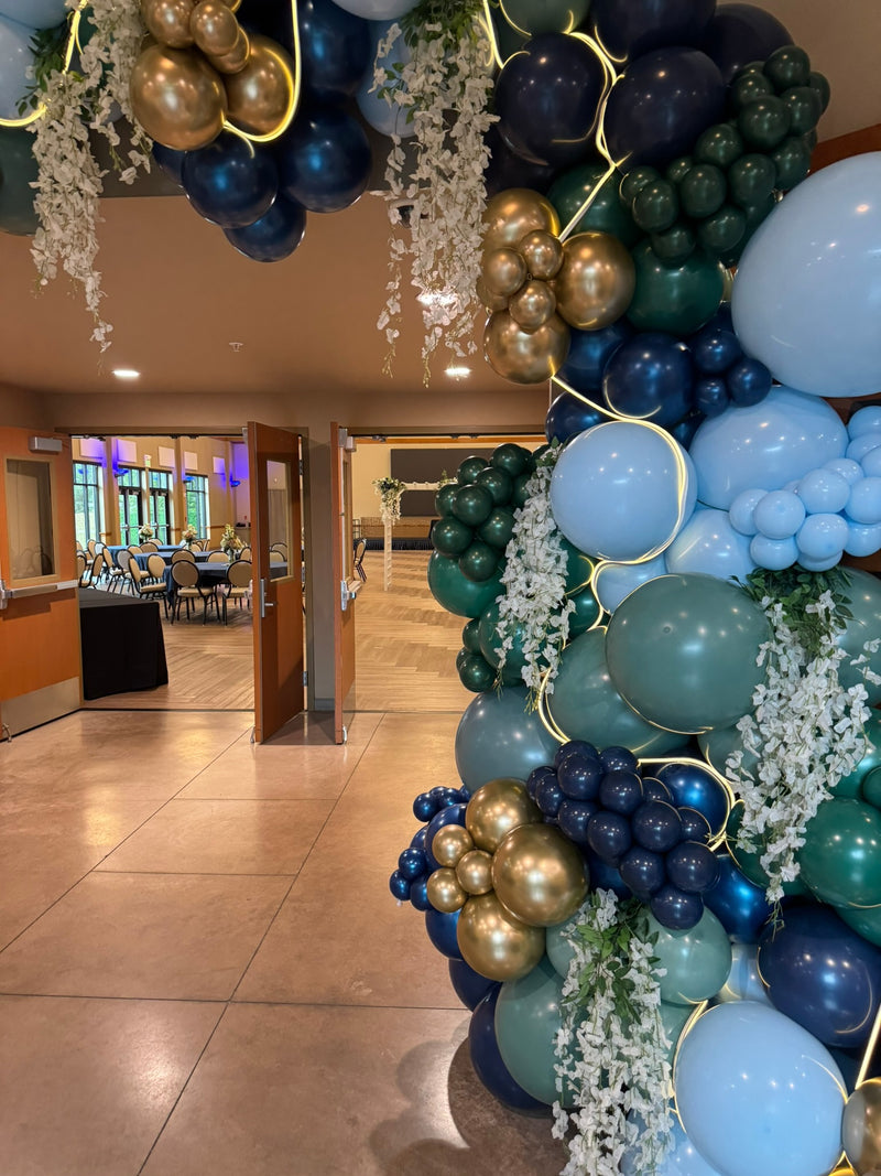 Navy teal and gold balloon garland over a casino entrance