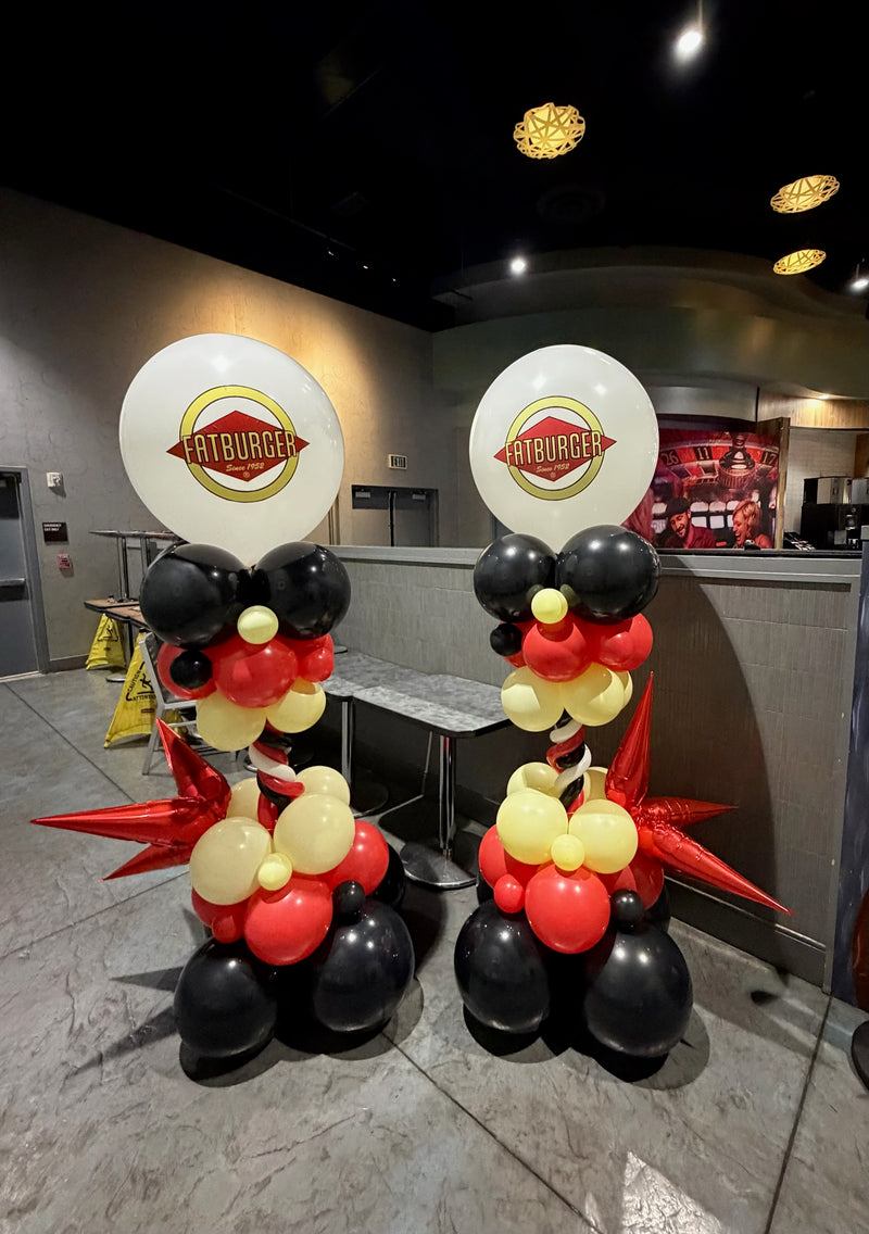 Pair of red black and gold party poles with logo balloons