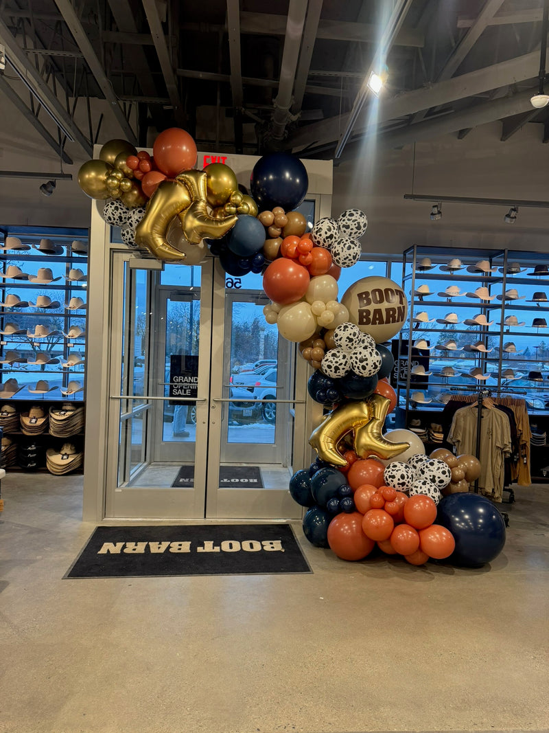 Navy gold and white balloon garland at a Boot Barn store entrance