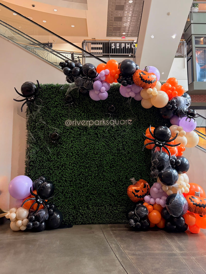 Halloween greenery wall at River Park Square with spiders and pumpkins