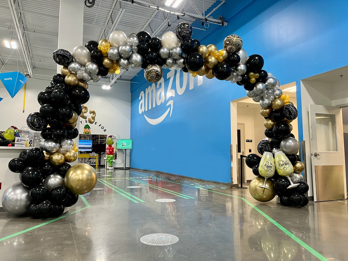 Black and gold balloon arch installed at an Amazon facility by Air with a Flair