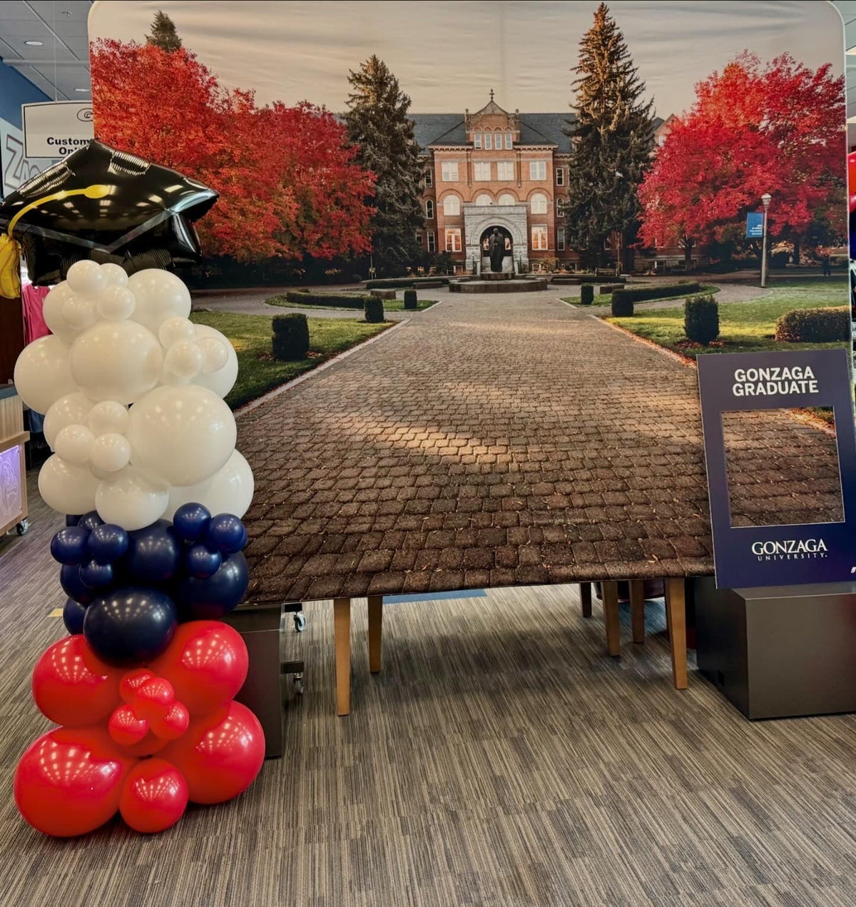 Balloon columns in Gonzaga navy and red at a graduation backdrop