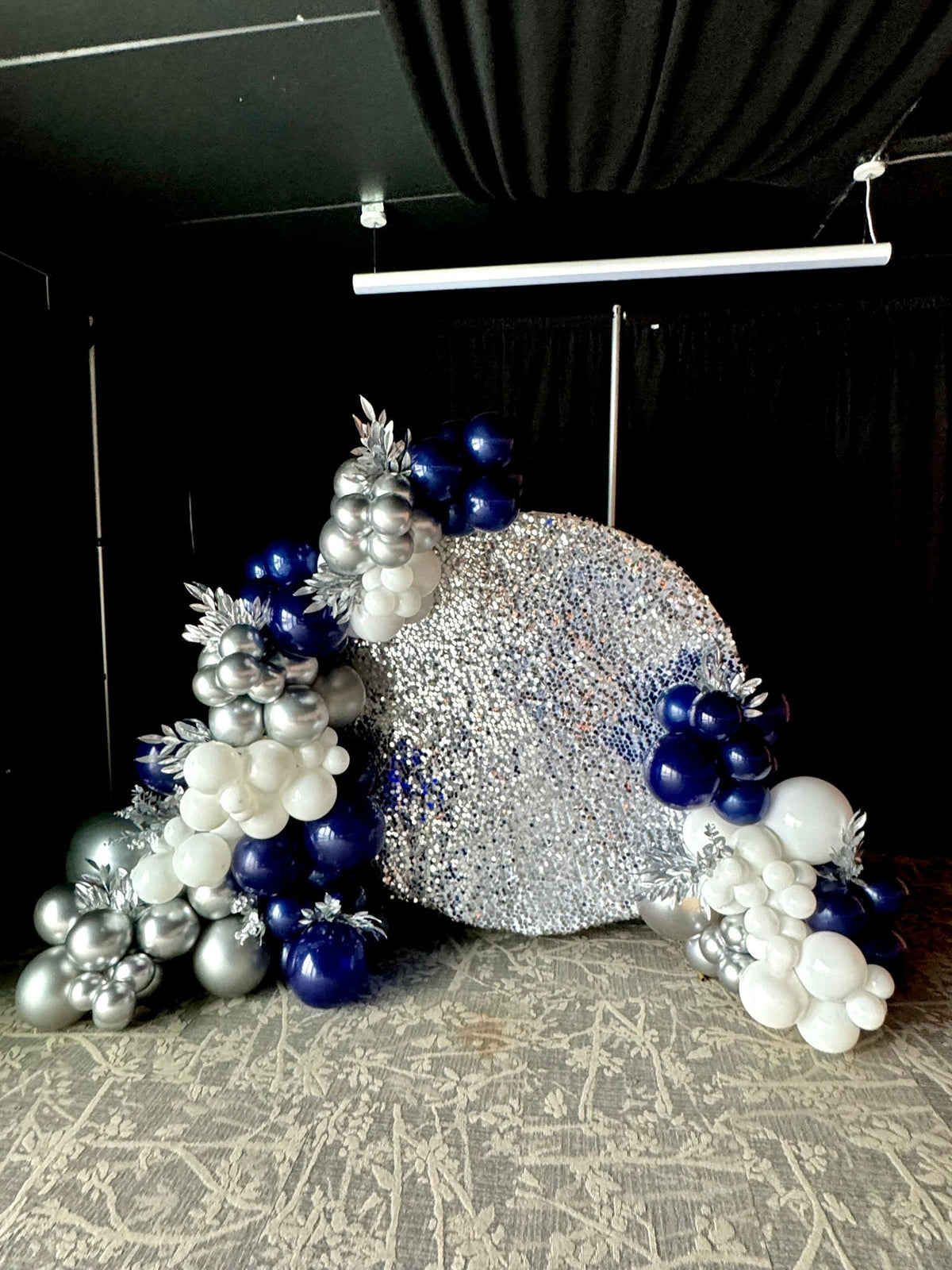 Room filled with white, navy and silver balloons by Air with a Flair